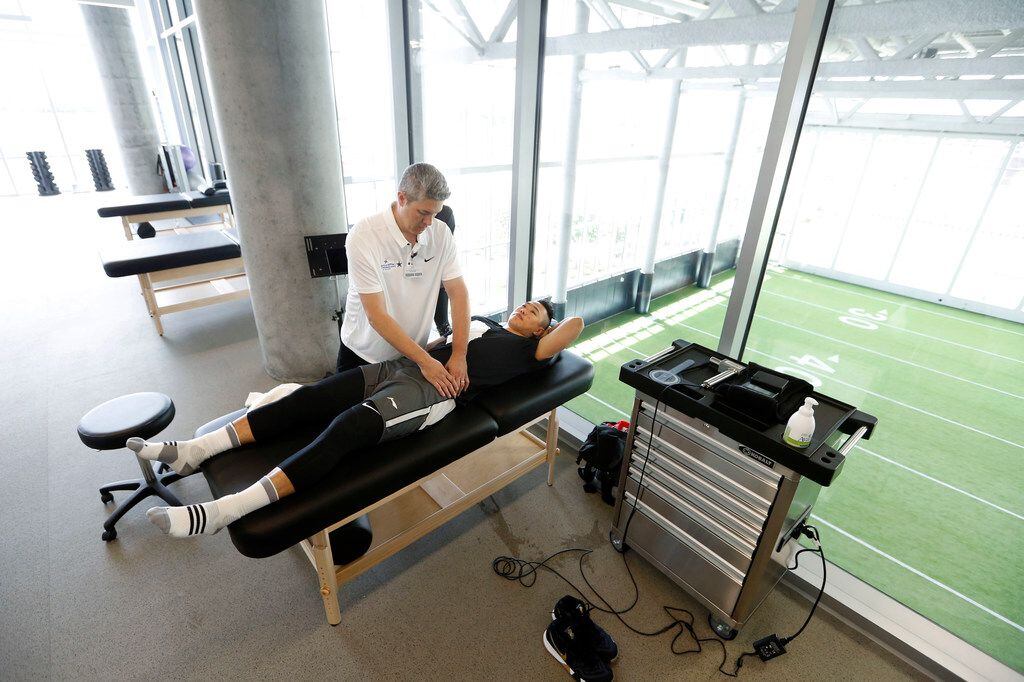 Michael Oviedo, director of performance health, works on Xining He, a basketball player from...