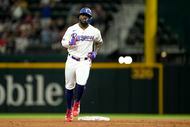 Texas Rangers' Adolis Garcia rounds the bases after hitting a solo home run in the second...