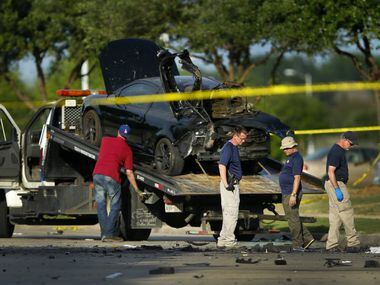 Members of the FBI Evidence Response team take a last look after the damaged car was loaded...