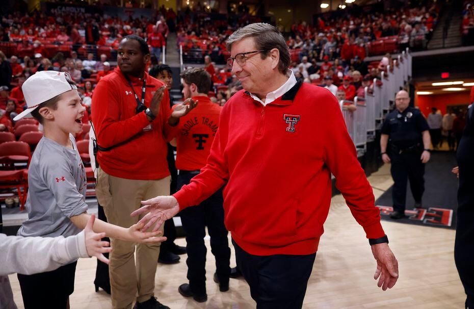 Texas Tech Red Raiders head coach Mark Adams (right) receives handshakes from fans as he...