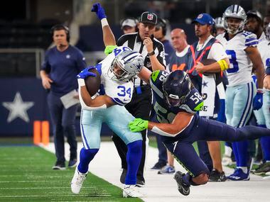 Dallas Cowboys running back Malik Davis (34) is pulled out of bounds by Seattle Seahawks...