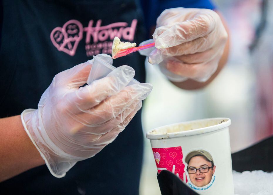 Coleman Jones, vice president of Howdy Homemade Ice Cream, hands out samples from a carton...