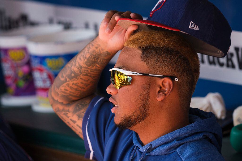 Texas Rangers outfielder Willie Calhoun watches from the dugout before a spring training...