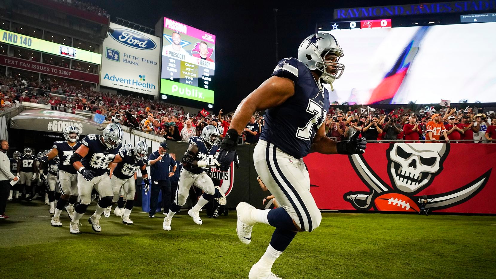 Dallas Cowboys offensive tackle La'el Collins (71) leads teammates onto the field before an NFL football game against the Tampa Bay Buccaneers at Raymond James Stadium on Thursday, Sept. 9, 2021, in Tampa, Fla.