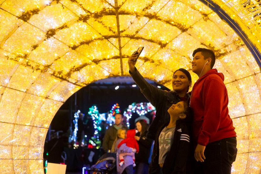 Liz Garcia takes a selfie with Gisselle Chuca ,10, and Jesus Chuca, 13, at Dallas Zoo Lights.