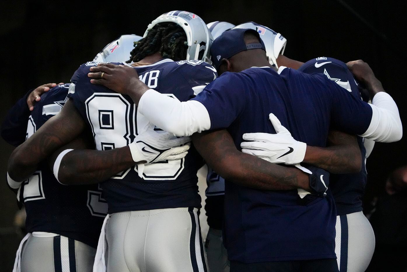 Dallas Cowboys wide receiver CeeDee Lamb joins teammates as they huddle before an NFL...