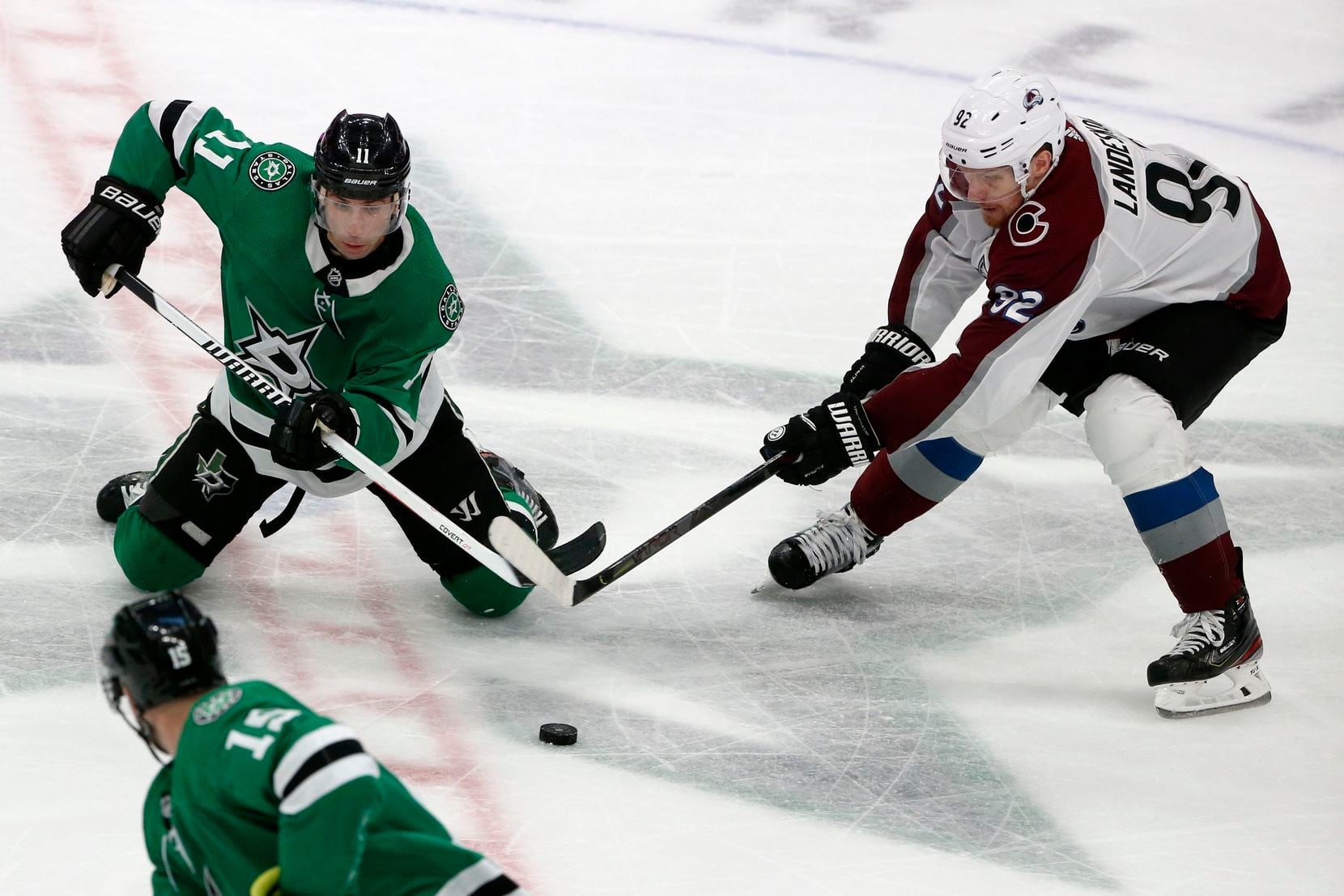 Dallas Stars center Andrew Cogliano (11) and Colorado Avalanche left wing Gabriel Landeskog (92) battle for the puck during the third period of an NHL hockey game in Dallas, Saturday, Dec. 28, 2019.