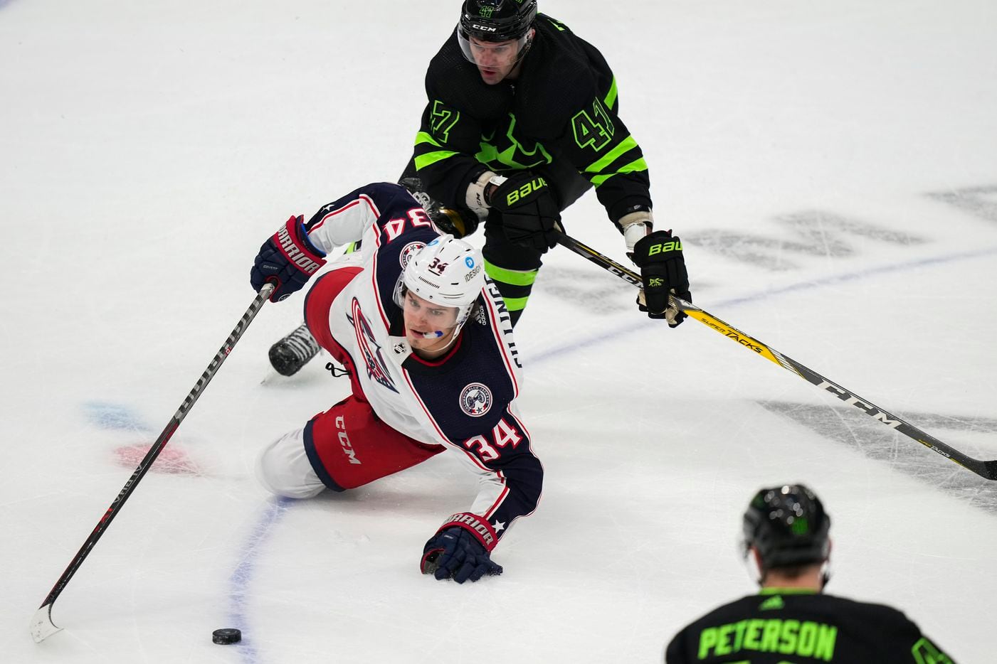 Columbus Blue Jackets center Cole Sillinger (34) slips to the ice as Dallas Stars right wing Alexander Radulov (47) defends during the third period of an NHL hockey game at the American Airlines Center on Thursday, Dec. 2, 2021, in Dallas.