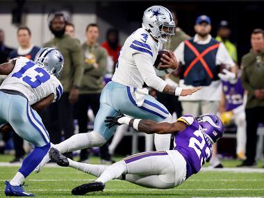 Dallas Cowboys quarterback Dak Prescott (4) stiff arms Minnesota Vikings cornerback Andrew...