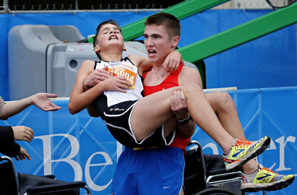 Trace Greer (right) carries his brother Judson Greer after they crossed the finish line...