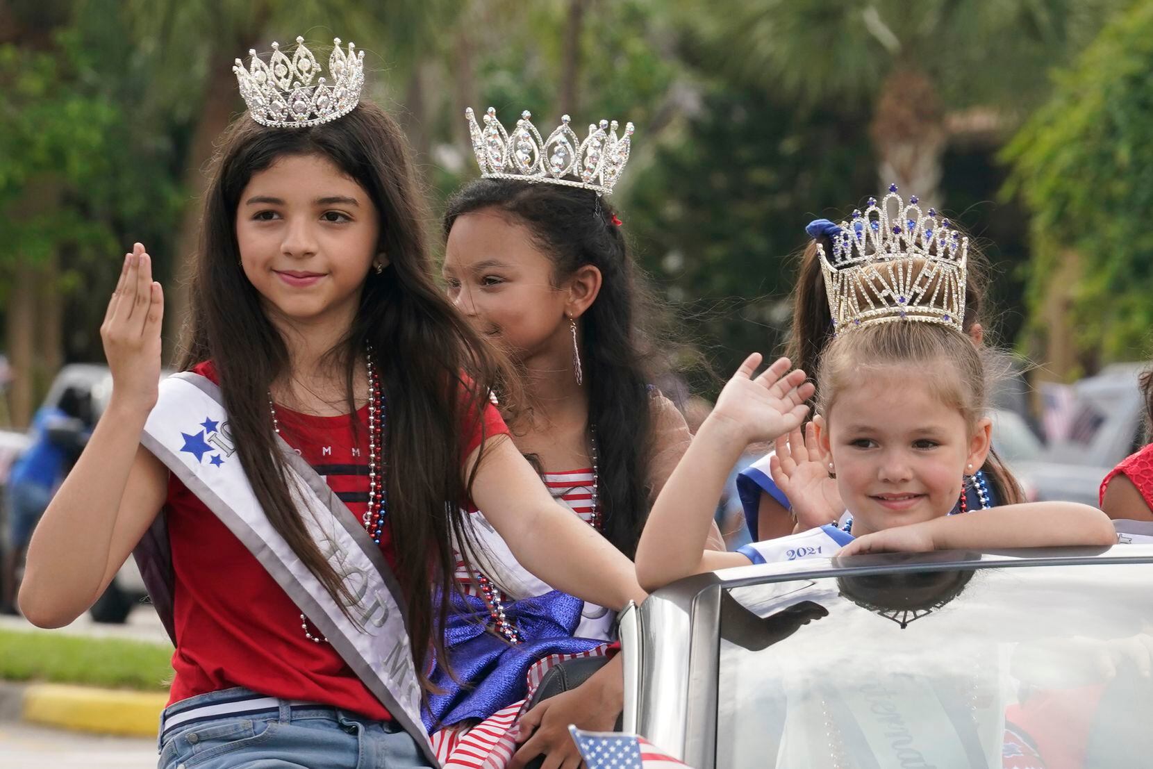 Members of the Florida International Girl pageant group waved during a Fourth of July parade...