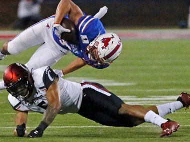 Southern Methodist Mustangs wide receiver Tyler Page (4) is upended by Cincinnati Bearcats safety Darrick Forrest (5) during the second half as SMU hosted Cincinnati University in an AAC football game at Ford Stadium in Dallas on Saturday night, October 24, 2020.