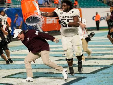Texas A&M offensive lineman Kenyon Green (55) douses head coach Jimbo Fisher at the end of the Orange Bowl NCAA college football game, Saturday, Jan. 2, 2021, in Miami Gardens, Fla. Texas A&M defeated North Carolina 41-27.