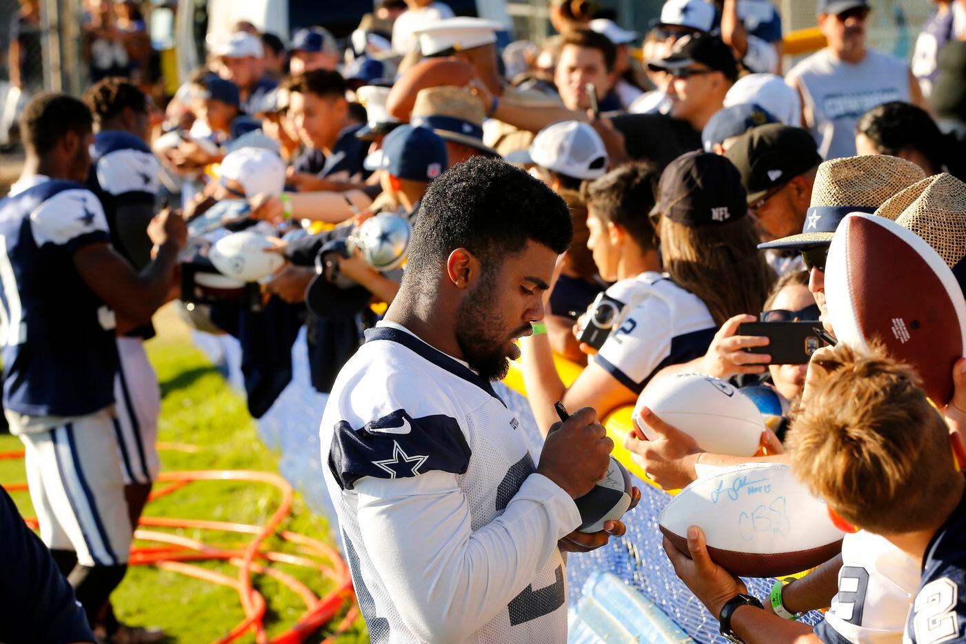 Dallas Cowboys running back Ezekiel Elliott (21) signs autographs for fans following...