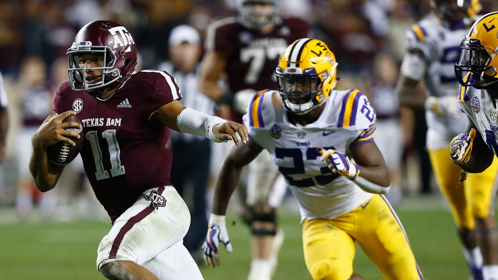 COLLEGE STATION, TEXAS - NOVEMBER 24: Kellen Mond #11 of the Texas A&M Aggies rushes past Micah Baskerville #23 of the LSU Tigers in overtime at Kyle Field on November 24, 2018 in College Station, Texas.