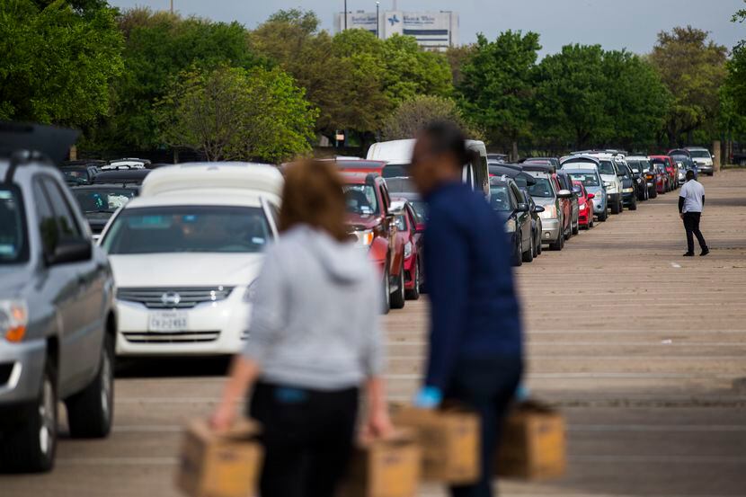 Hundreds of vehicles lined up to receive food during a distribution event put on by the...