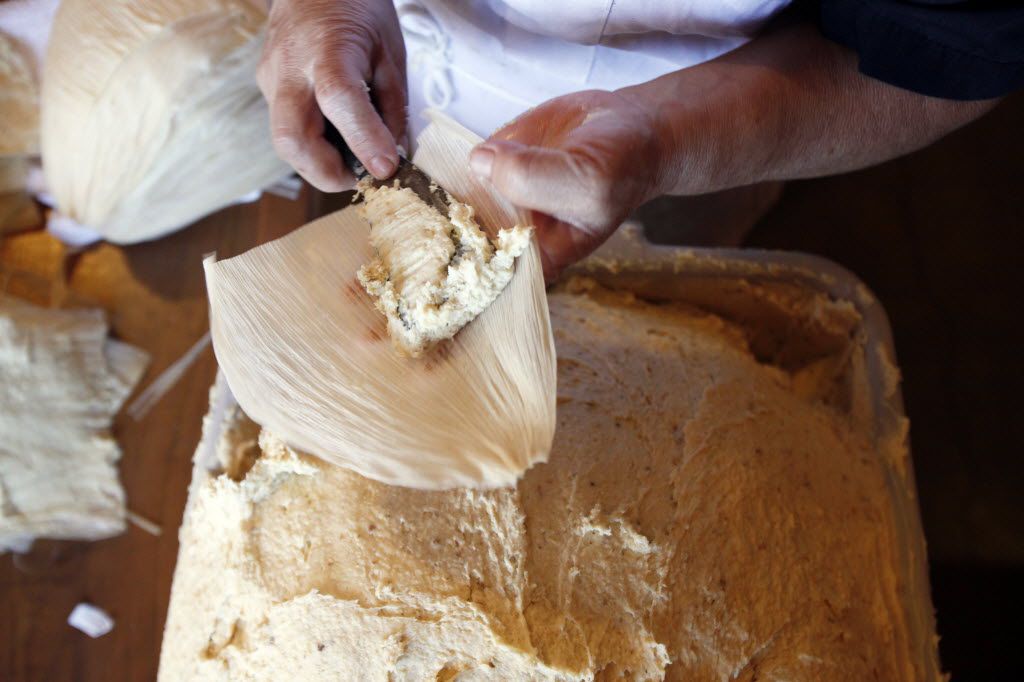 Armandina Flores, 47, places a corn based dough into a corn husk as she prepares tamales to...