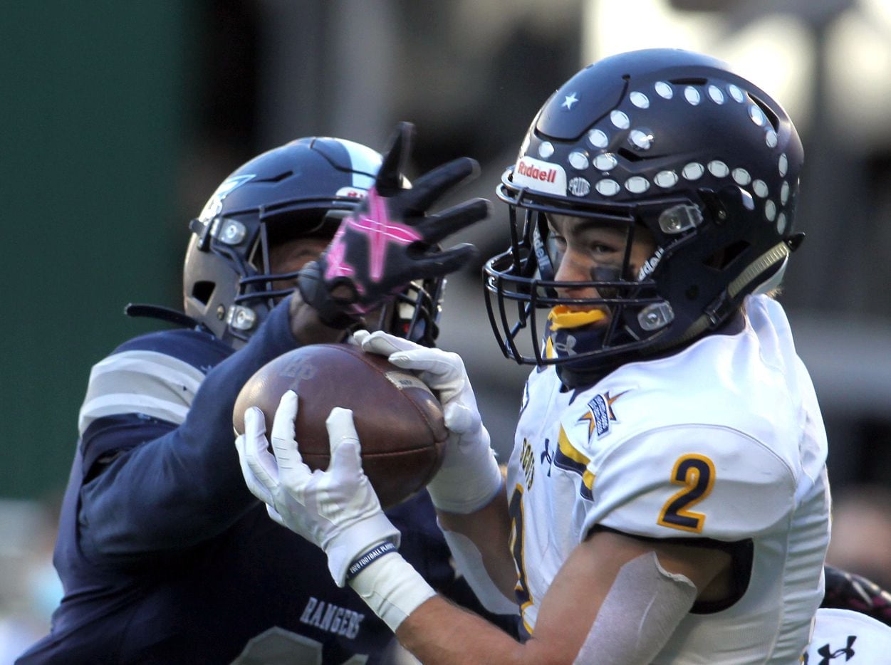 Highland Park receiver Will Pettijohn (2) pulls in a touchdown pass over the defense of...