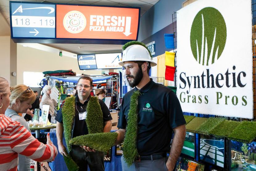 Sean Quillin (right) and Jason Waller of Synthetic Grass Pros talk about their product with...