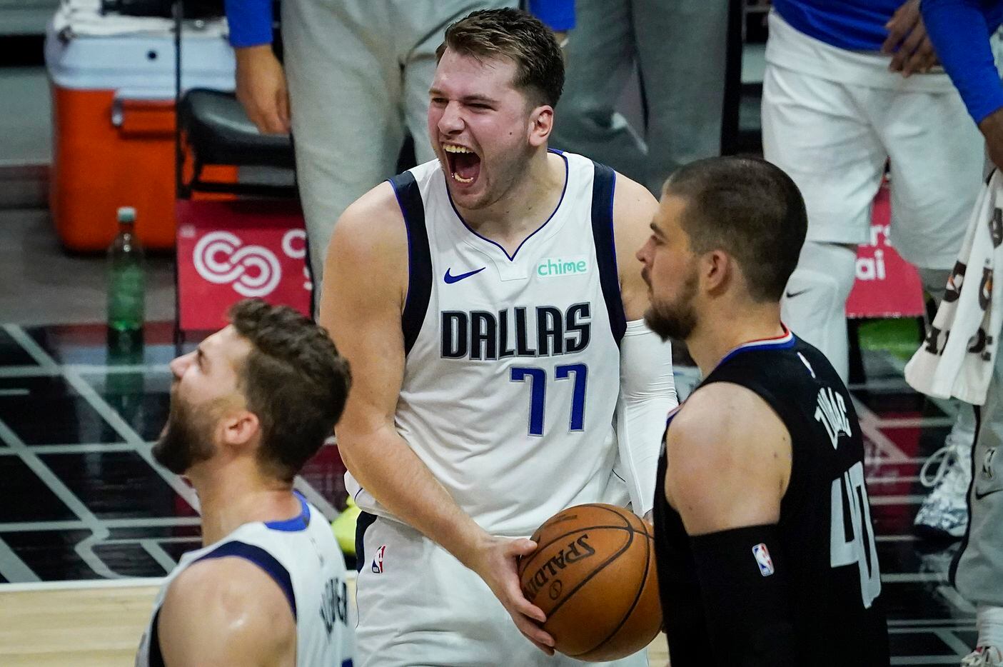 Dallas Mavericks guard Luka Doncic (77) celebrates with forward Maxi Kleber (42) as LA Clippers center Ivica Zubac (40) walks away after the final buzzer of the Mavericks 127-121 victory in an NBA playoff basketball game at Staples Center on Wednesday, May 26, 2021, in Los Angeles. 