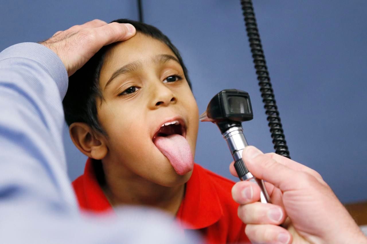 Dr. Robert Sugerman checks out Nathan Abraham, 5, of Garland at the Dallas Allergy and...