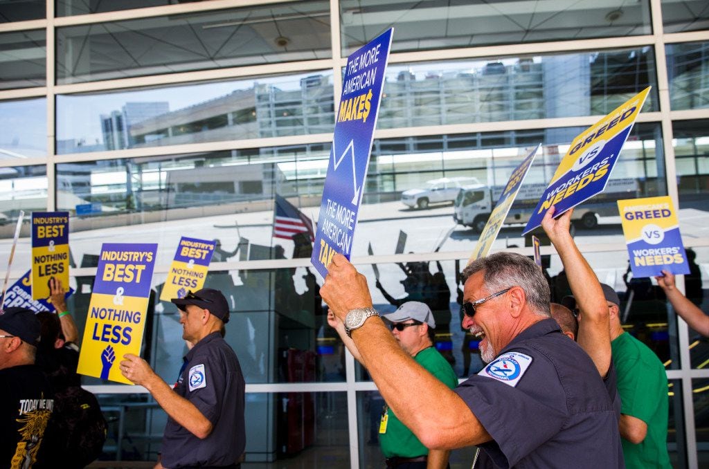 American Airlines employees protest the lack of a new contract for baggage carriers,...