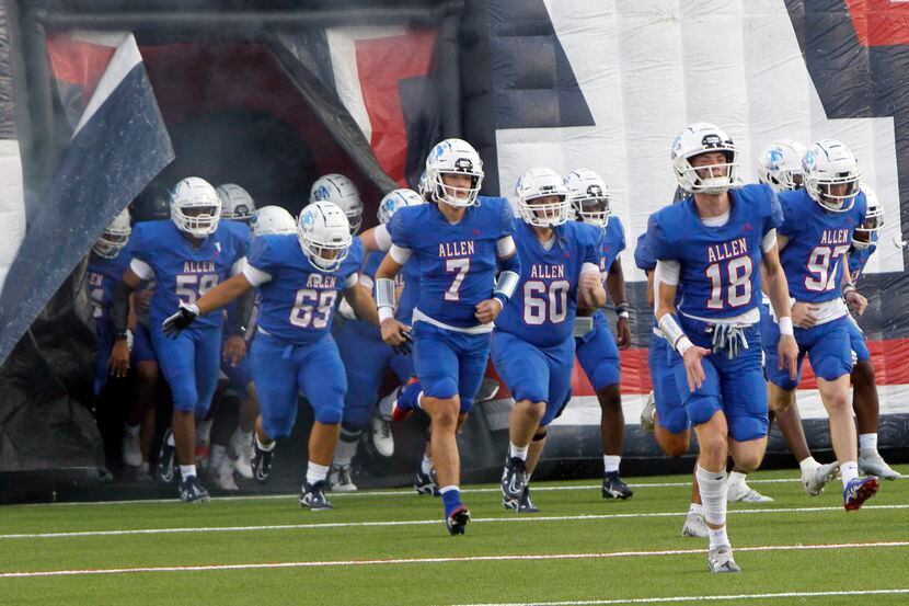 Allen Eagles players emerge from the team inflatable prior to the opening kickoff against...