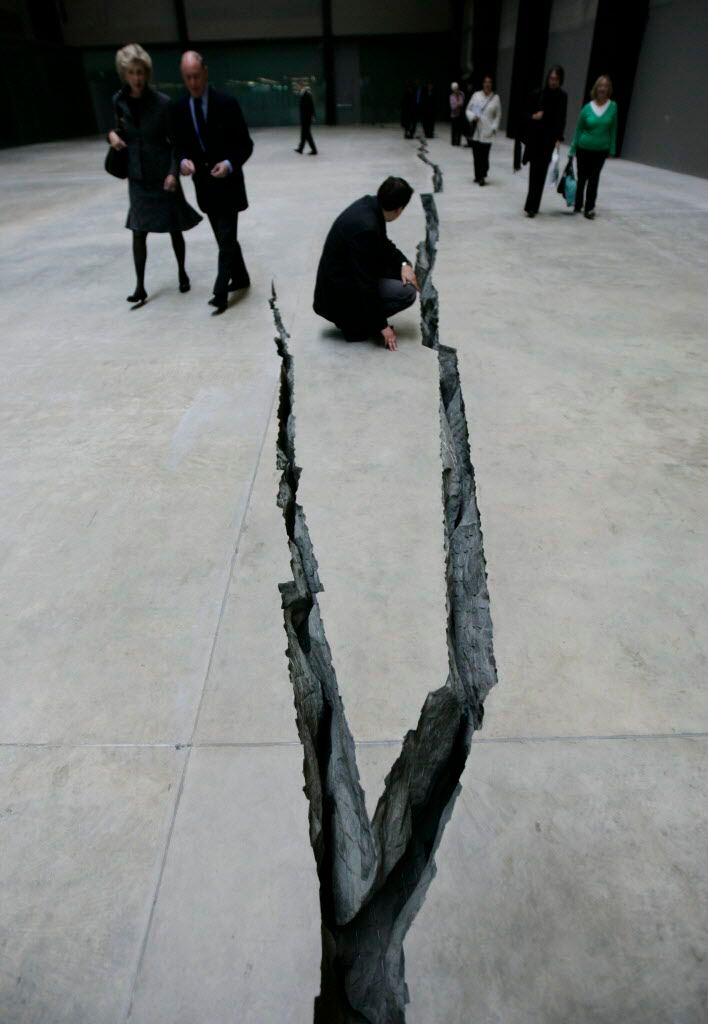  A visitor examines a crack in the floor titled 