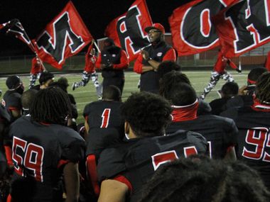 Cedar Hill head coach Carlos Lynn shares a congratulatory message to his team as members of the Red Army Flag Runners sprint past in the background following the Longhorn's 49-42 victory over DeSoto. The two teams played their District 11-6A  football game at Longhorn Stadium in Cedar Hill on November 6, 2020. (Steve Hamm/ Special Contributor)