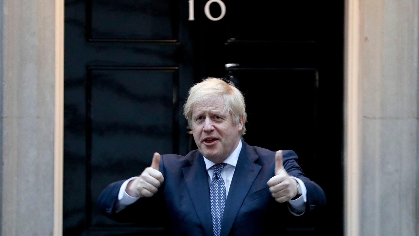 El primer ministro británico Boris Johnson hace una señal de aprobación a la entrada del...