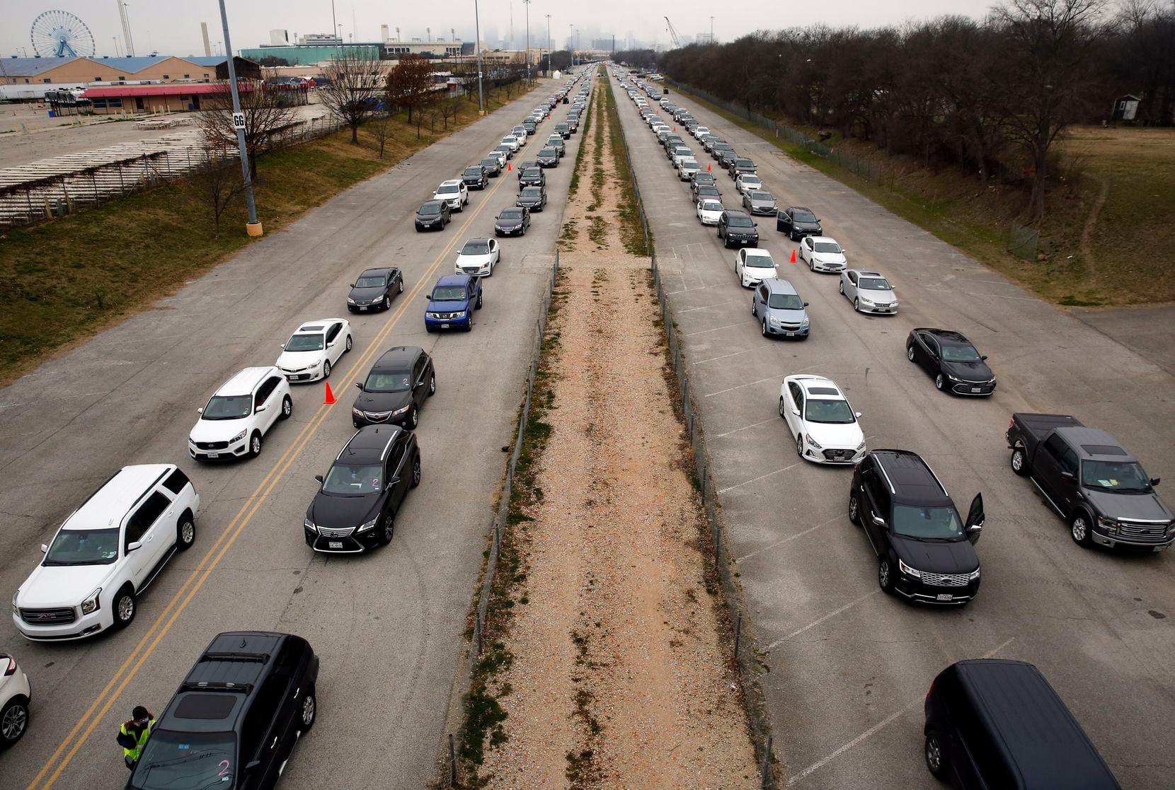 Vehicles line up at Fair Park to receive COVID-19 vaccines in Dallas, Wednesday, Feb. 10,...
