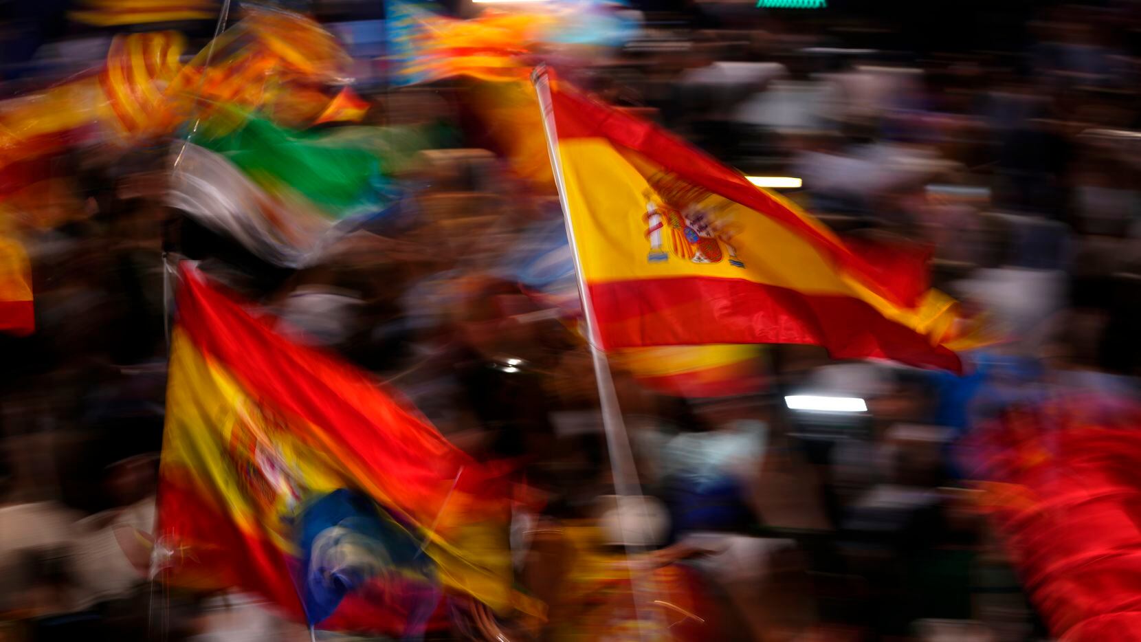 Simpatizantes del Partido Popular ondean banderas de España mientras esperan la...
