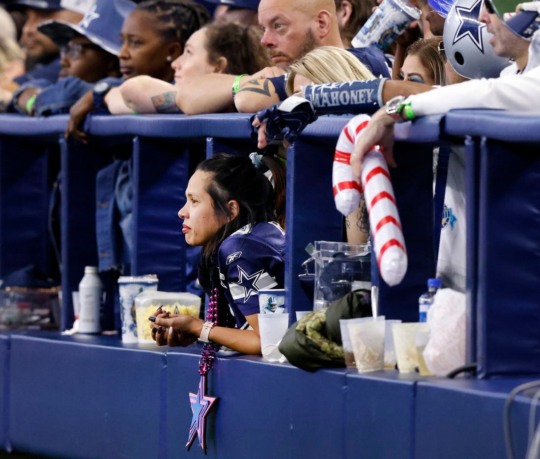Dallas Cowboys fans watch the game from the field level club during the first half of the...
