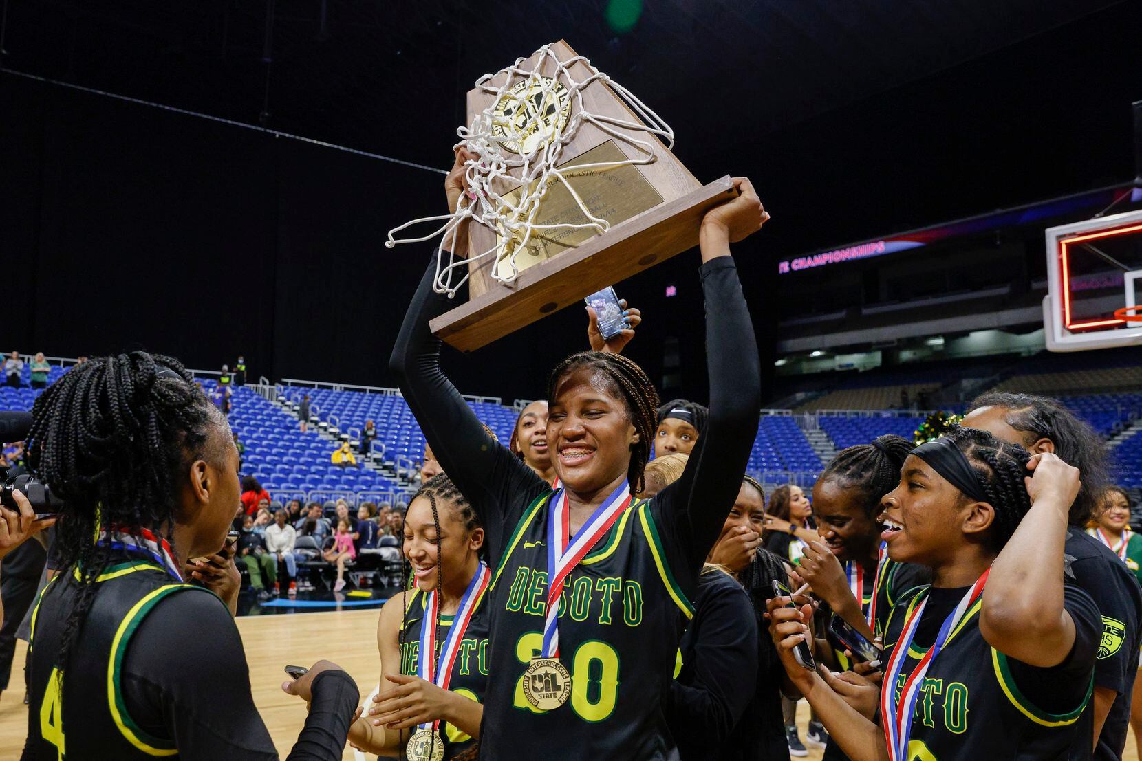 DeSoto guard Ayanna Thompson (20) raises the Class 6A state championship trophy with her...