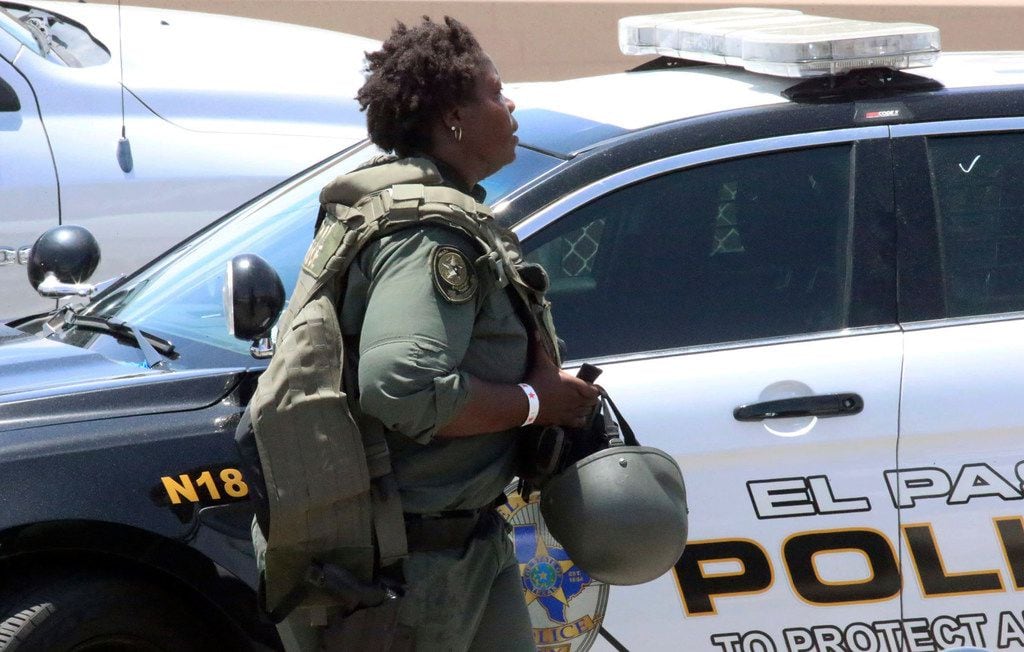 A law enforcement officer walks near the scene of a shooting at a shopping mall in El Paso,...