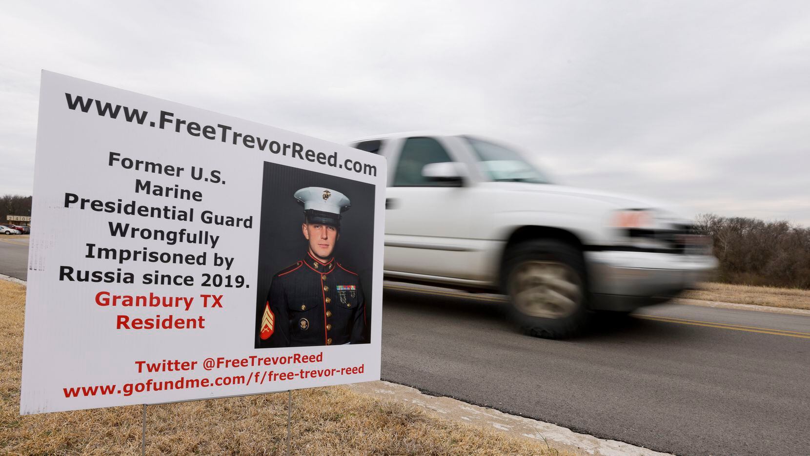 A truck drives past a sign for imprisoned former Marine Trevor Reed near the Tarrant County...