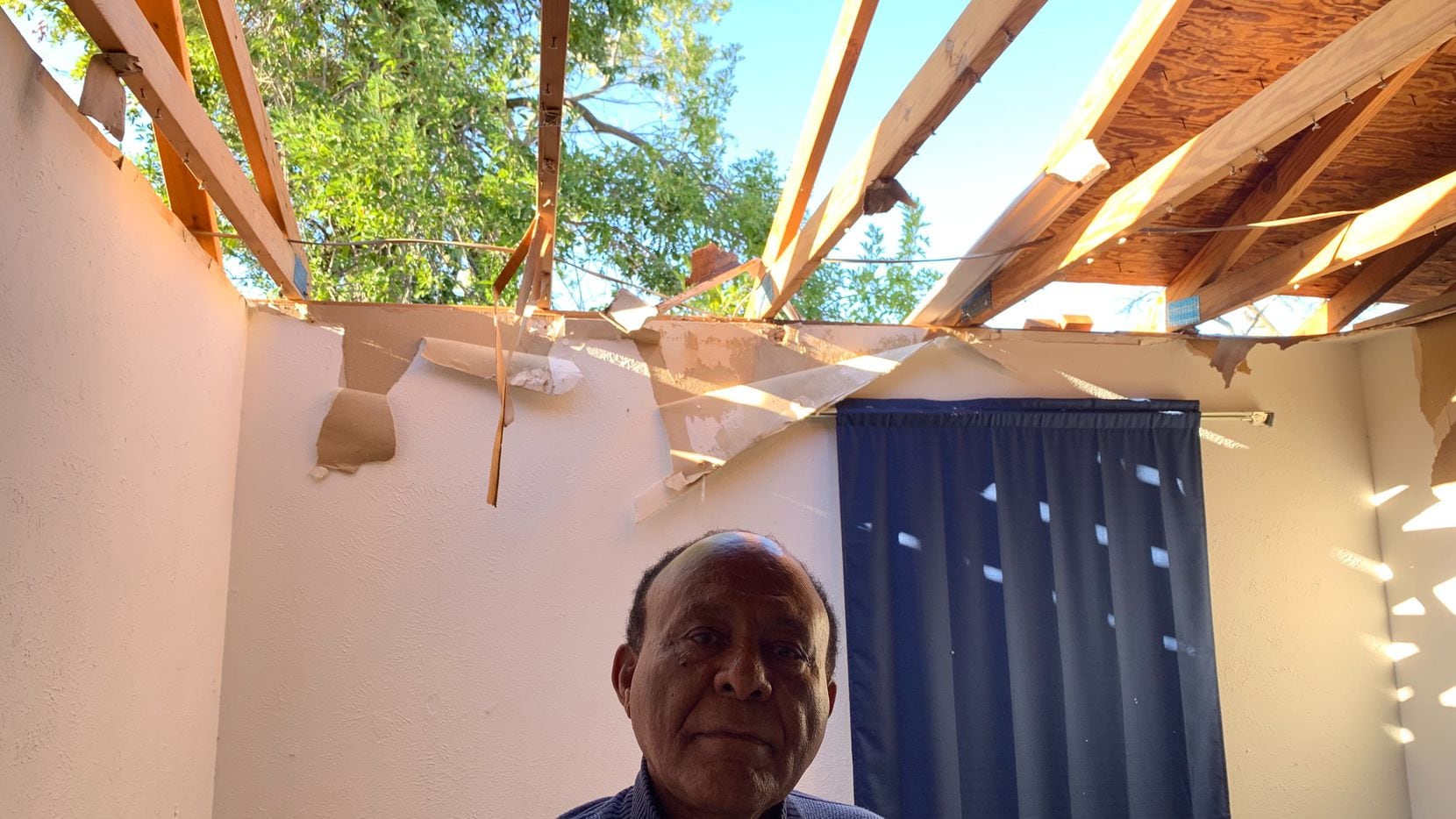 Gizaw Gedlu, 71, stands in his Richardson home that was destroyed by a tornado Sunday night.