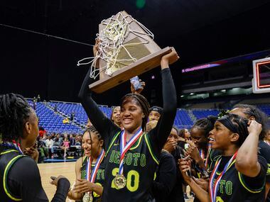 DeSoto guard Ayanna Thompson (20) raises the Class 6A state championship trophy with her...