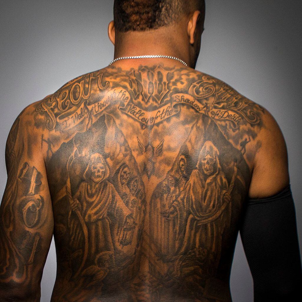Texas Rangers outfielder Delino DeShields poses for a photo displaying his back tattoo after...
