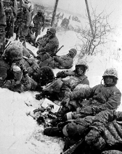 U.S. Marines, fighting their way from Chosin to Hungnam, Korea, take a rest in the snow...
