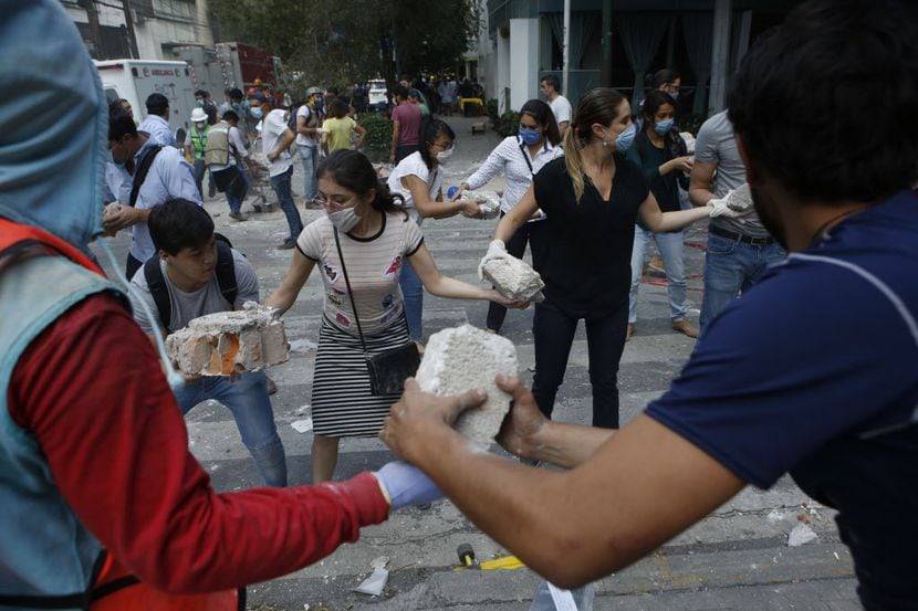 Voluntarios recogen los escombros de un edificio que se derrumbó durante un terremoto en el...
