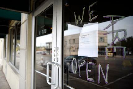 A handwritten sign tells Starbucks customers they are open, despite the fact that the dining...
