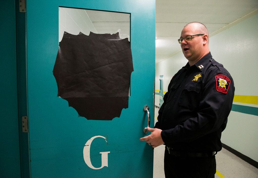 Capt. Matthew Kimbler, the jail administrator, shows black paper covering a window for...