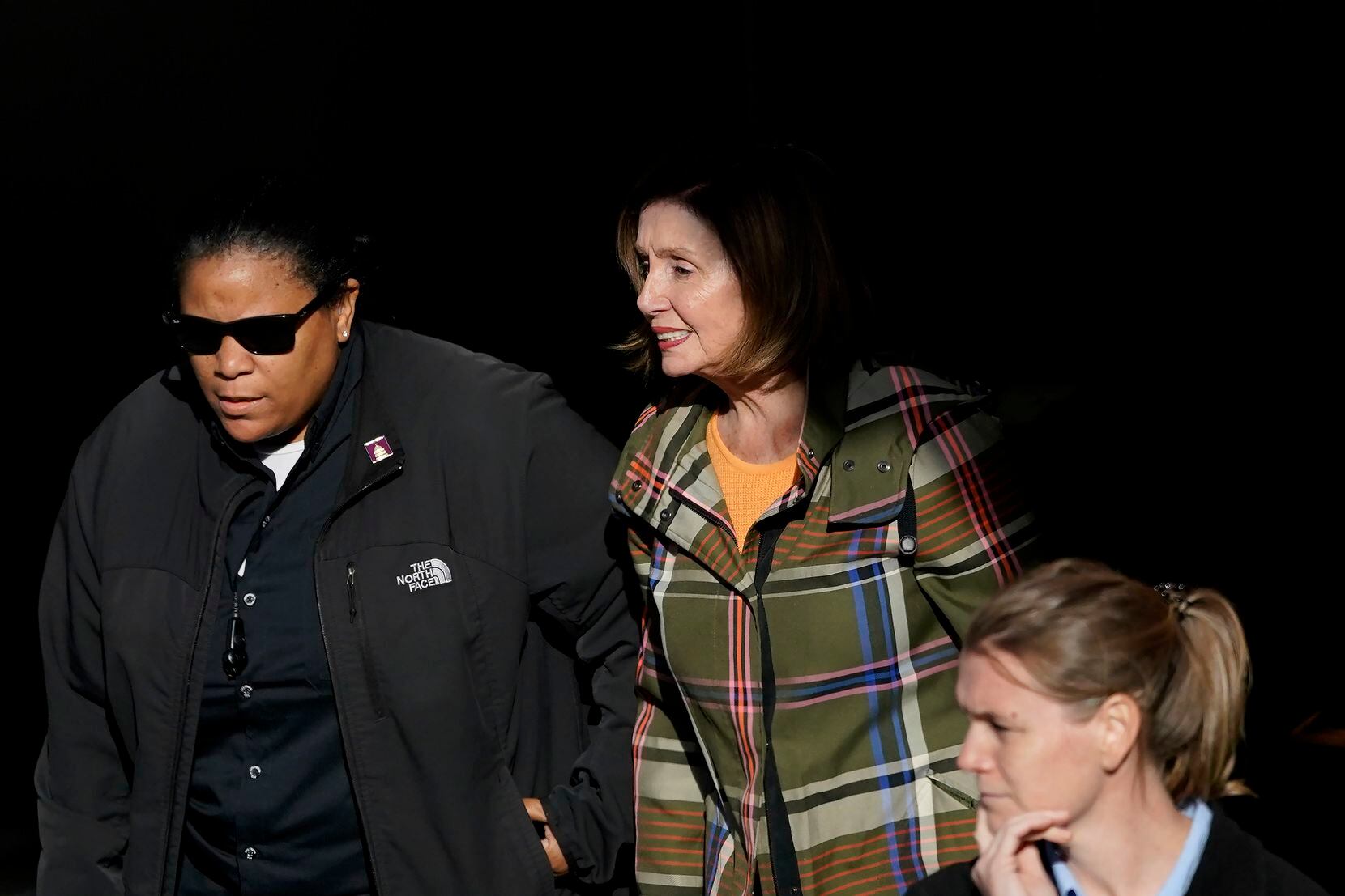 House Speaker Nancy Pelosi, middle, is escorted to a vehicle outside of her and husband Paul...