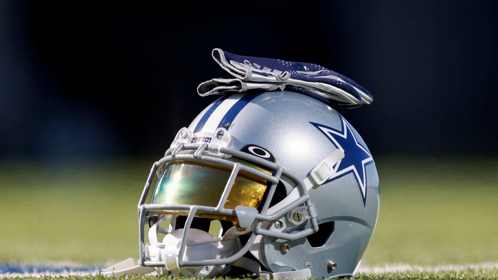 A Dallas Cowboys helmet rests on the practice field at The Star in Frisco, Texas, Thursday,...
