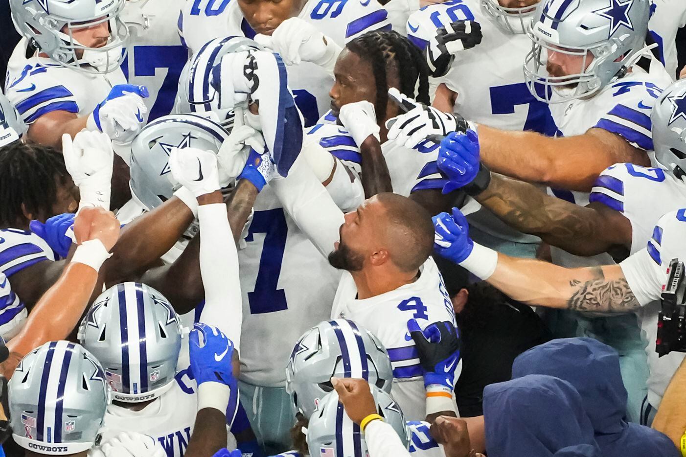 Dallas Cowboys players huddle around quarterback Dak Prescott (4) before an NFL football...