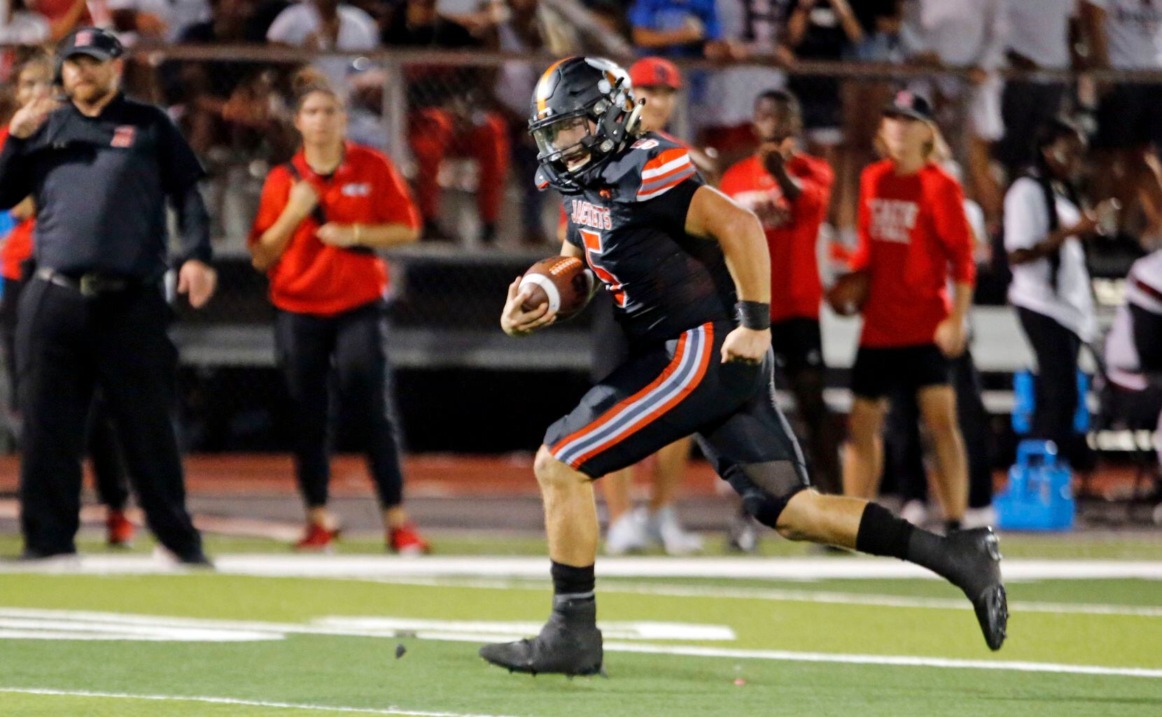 Rockwall high QB Lake Bennett (5) take set ball to the end zone for a second tome on a trick...