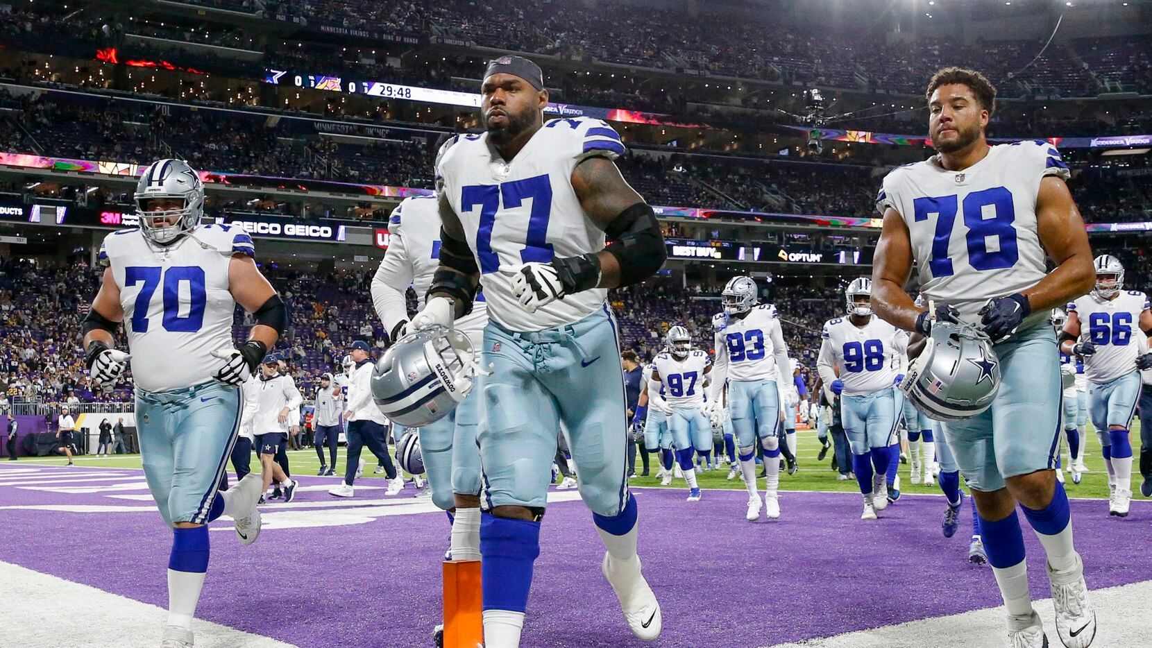 Dallas Cowboys offensive tackle Tyron Smith (77) jogs off the field with guard Zack Martin...