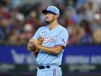 Texas Rangers starting pitcher Dane Dunning walks behind the mound as he works in the second...