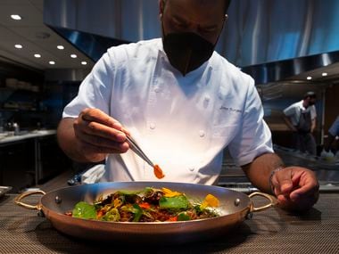 Chef Junior Borges (CQ) puts the final touches on the grilled octopus at Meridian restaurant.